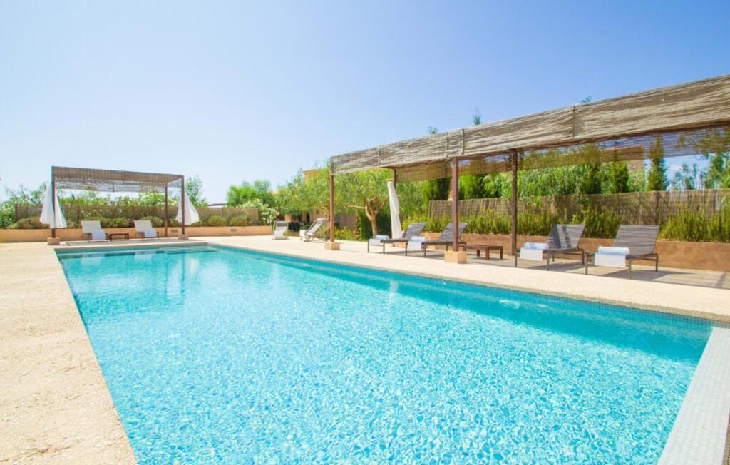 a swimming pool with chairs and a house at Son Sec Nou in El Palmer