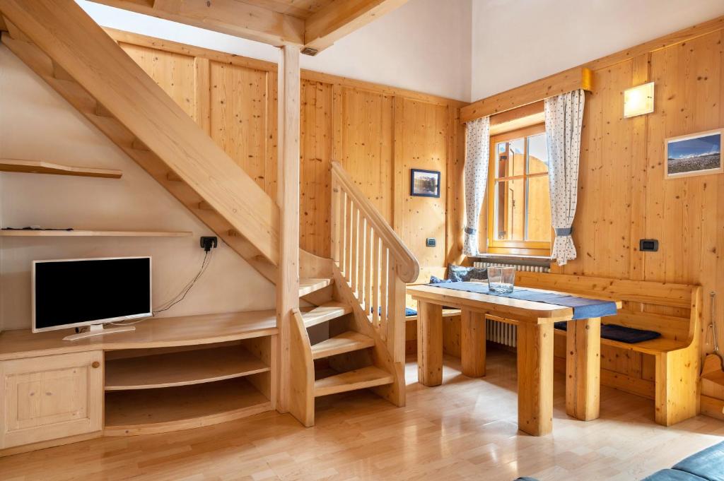 a room with a staircase with a desk and a tv at Apartment Vajolet in Campitello di Fassa