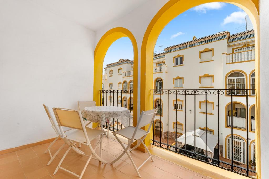 a balcony with a table and chairs and a building at Good Atmosphere in Orihuela