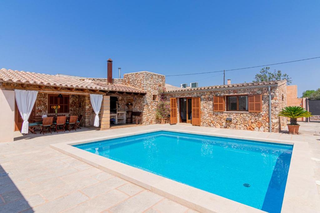 a villa with a swimming pool in front of a house at Hortet in Campos