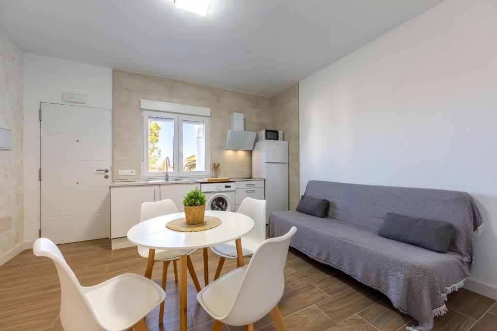 a living room with a couch and a table and chairs at La palmera in Níjar
