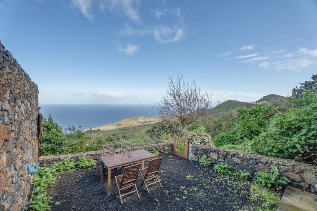 a table and chairs sitting on top of a stone wall at El Ciruelo in Valverde