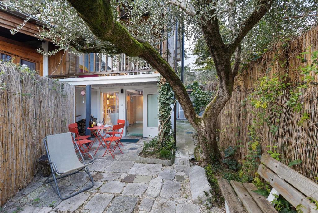 a patio with a tree and a wooden fence at Haus am Gardasee mit Seeblick in Raffa