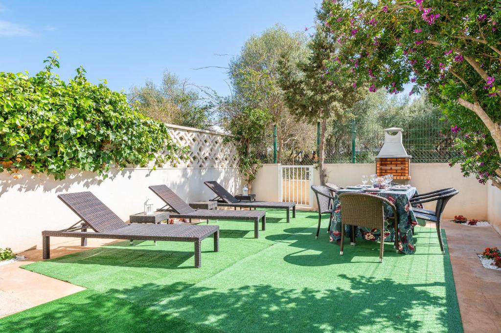 a patio with chairs and a table on a green rug at Ferrera Soul 1b in Santanyi