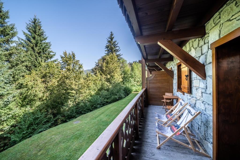 a deck with chairs on the side of a house at Appart Cosy 3 étoiles in Arâches-la-Frasse