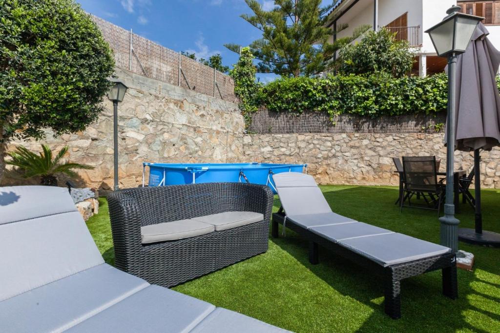 a garden with two chairs and an umbrella at Bruc Apartment Beach in Canet de Mar