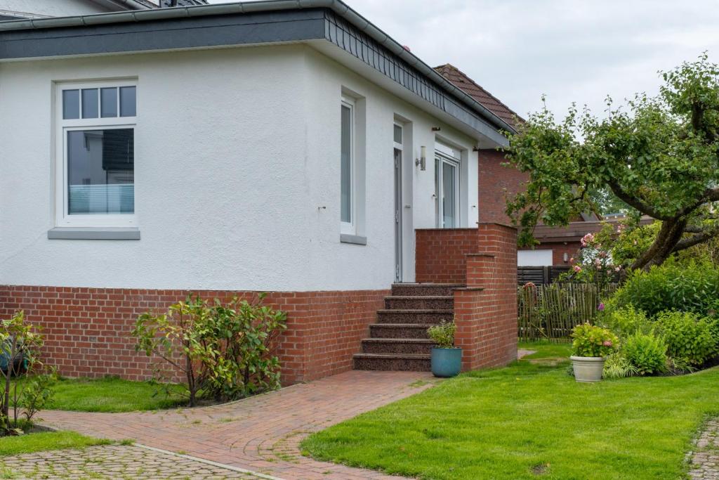 a white and red brick house with a brick yard at Ferienwohnung Alte Liebe in Cuxhaven