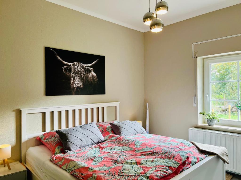 a bedroom with a bed with a cow on the wall at Am Conradhof 2 in Goch