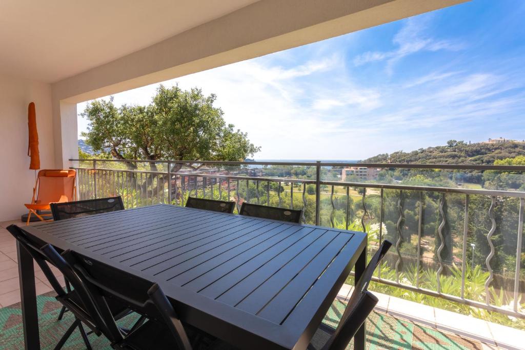 a table and chairs on a balcony with a view at Le Plein Sud Terrasse vue mer Agay in Saint-Raphaël
