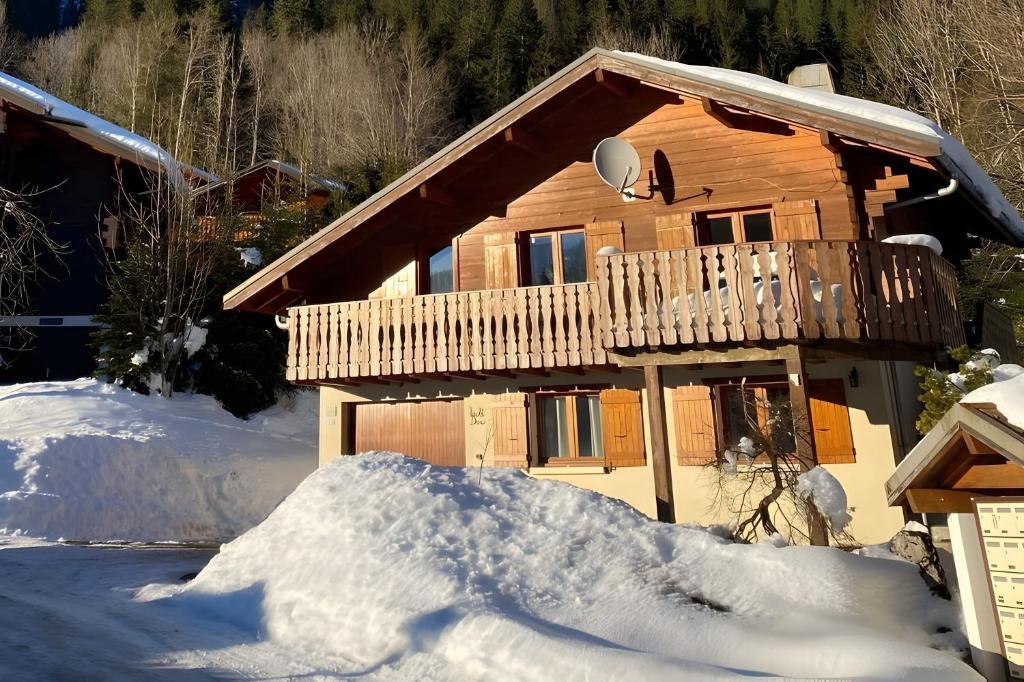 a log cabin with a deck in the snow at Chalet Chocolat - 10 pers - Châtel in Châtel