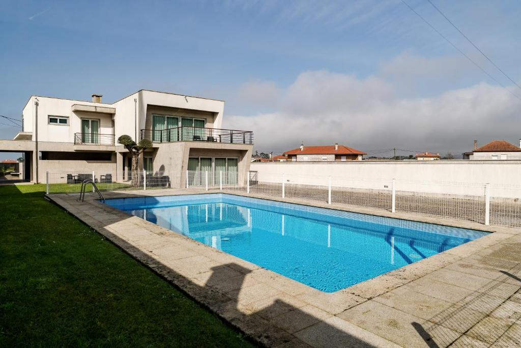 a swimming pool in front of a house at Casa Do Chino in Esposende