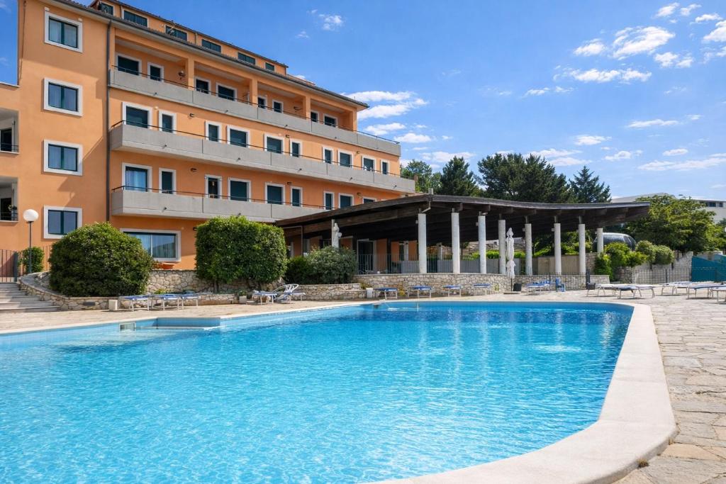 a large swimming pool in front of a building at Santangelo in Monte SantʼAngelo