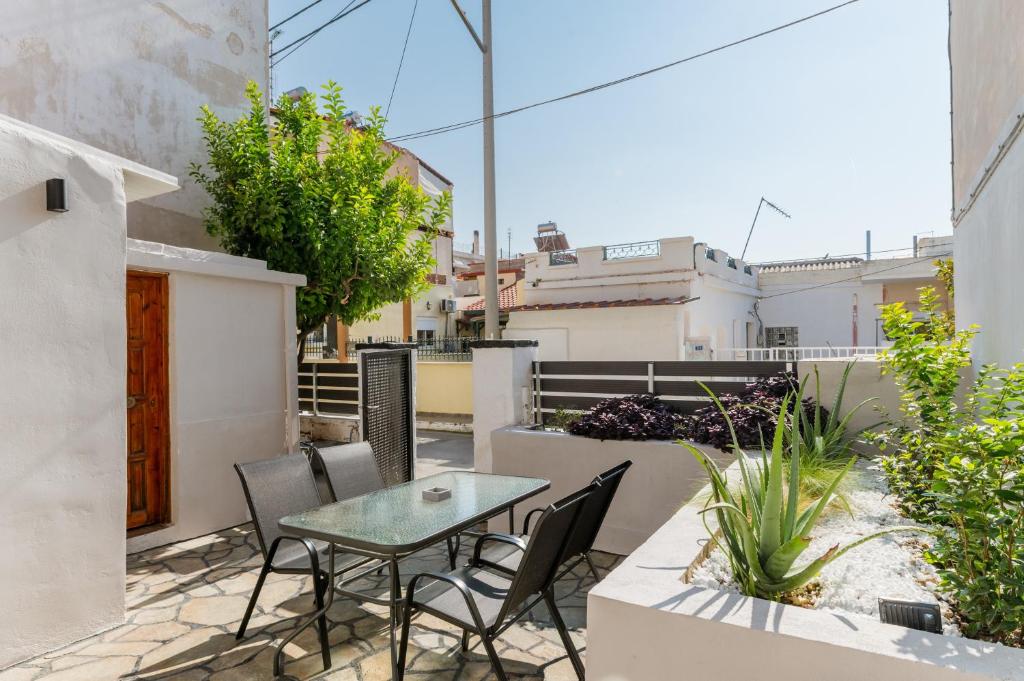 eine Terrasse mit Tisch und Stühlen auf einem Balkon in der Unterkunft Azure Nest in Néa Péramos