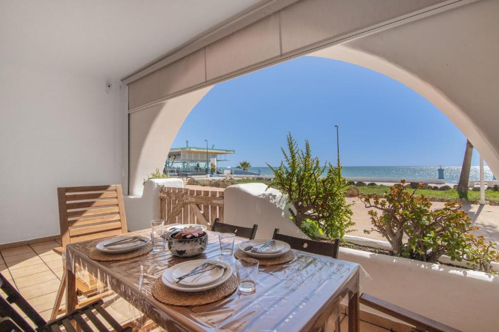 a dining table with a view of the beach at Primera Linea en Matalascañas in Matalascañas