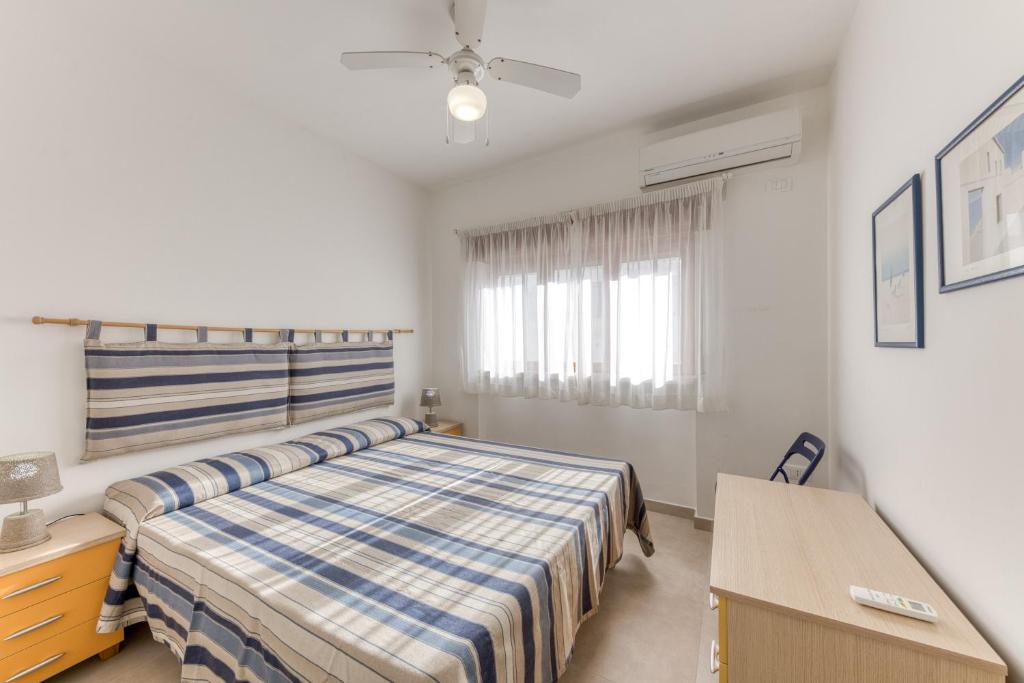 a bedroom with a bed and a desk and a window at Franza 2 in Torre San Giovanni Ugento