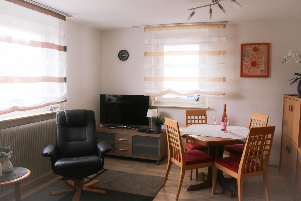 a dining room with a table and chairs and a television at Ferienwohnung Talblick in Meßstetten