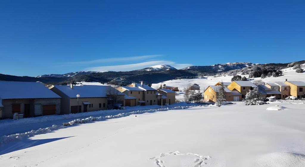 a town covered in snow with mountains in the background at Appartement Roc Sol I Neou in Puyvalador