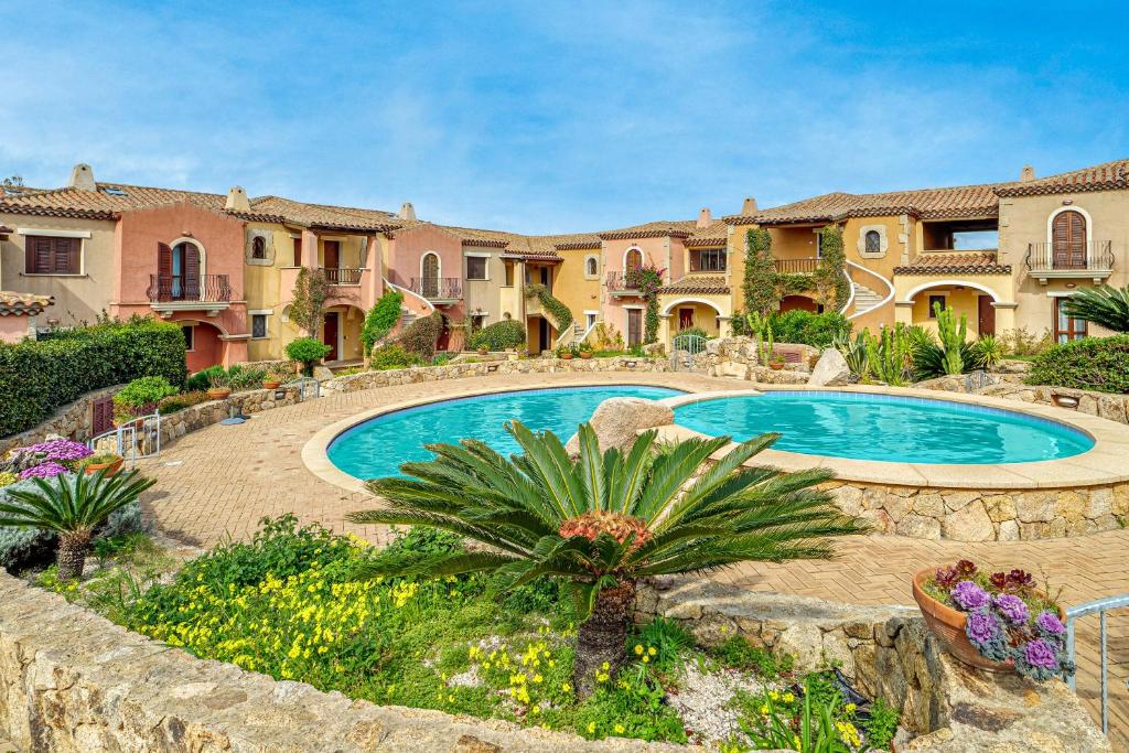 a large house with a swimming pool in a yard at Mazzini Apartment - by And Service in Golfo Aranci