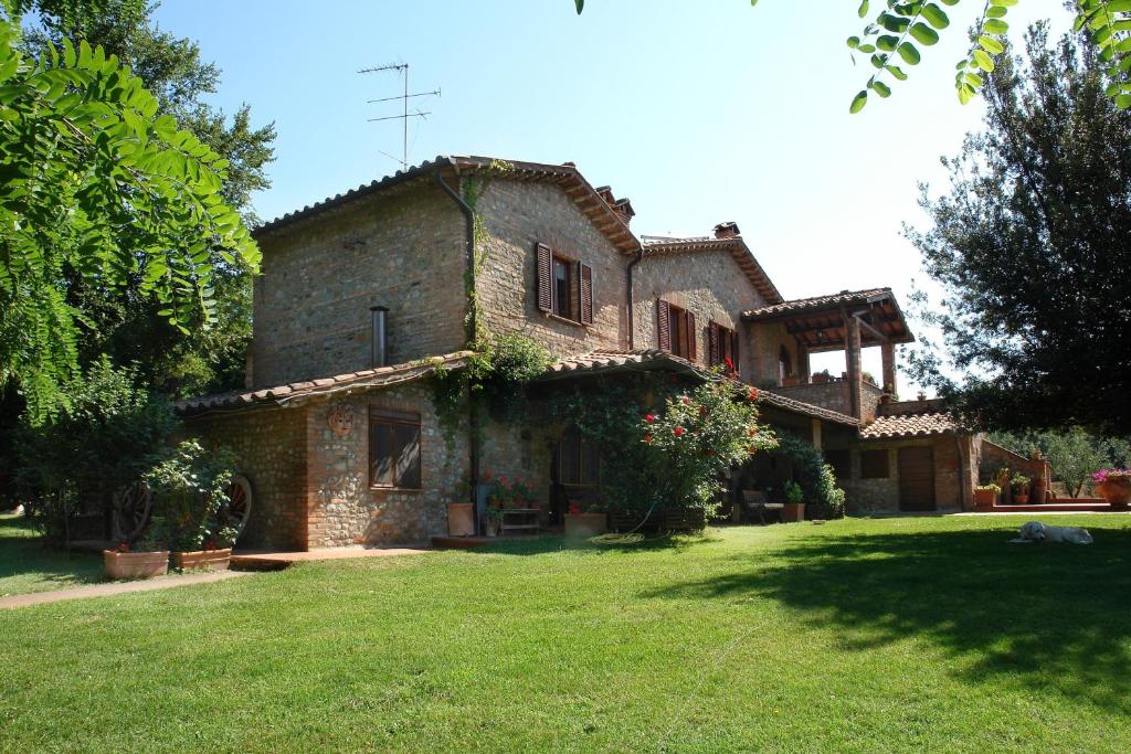 an old stone house with a grass yard at La Cerretola in Città della Pieve