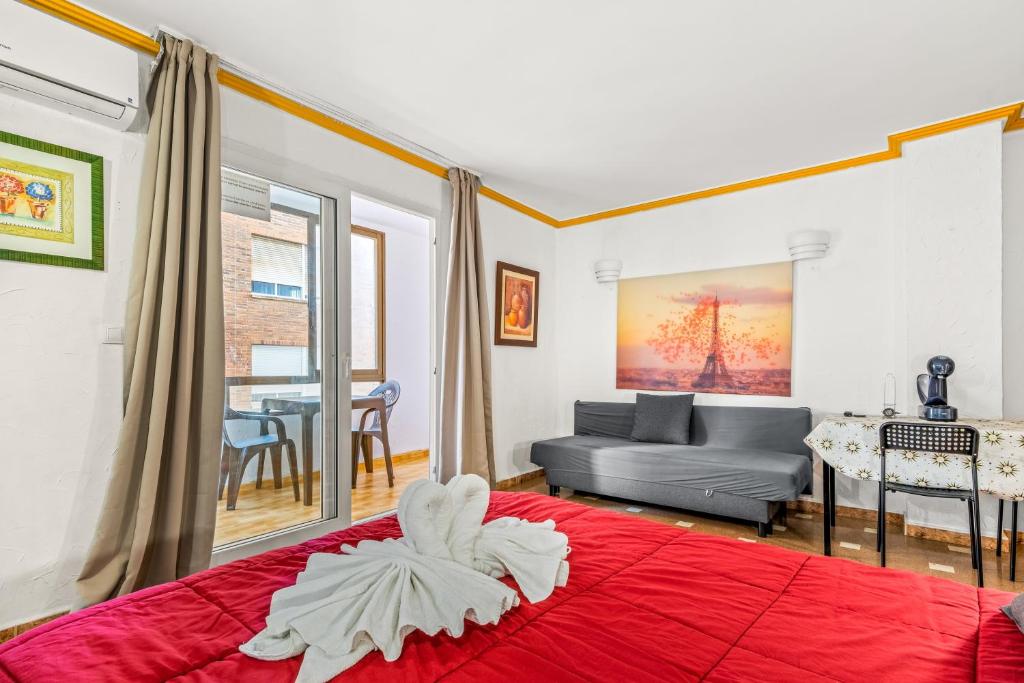 a bedroom with a red bed and a living room at Unique hotel apartment 1-2 in Torrevieja