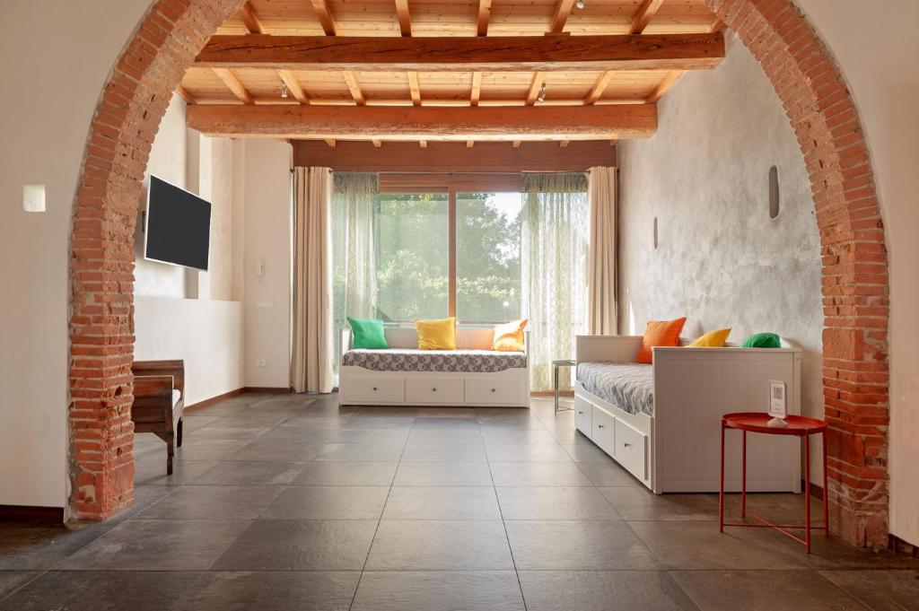 a living room with a bed and a window at Sunflowers Dimora in Cascina