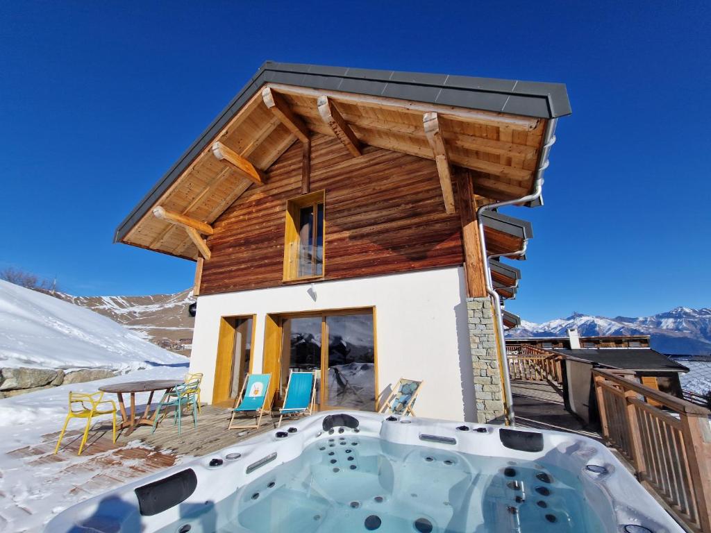a log home with a hot tub in the snow at Germain Ski Lodge in La Toussuire