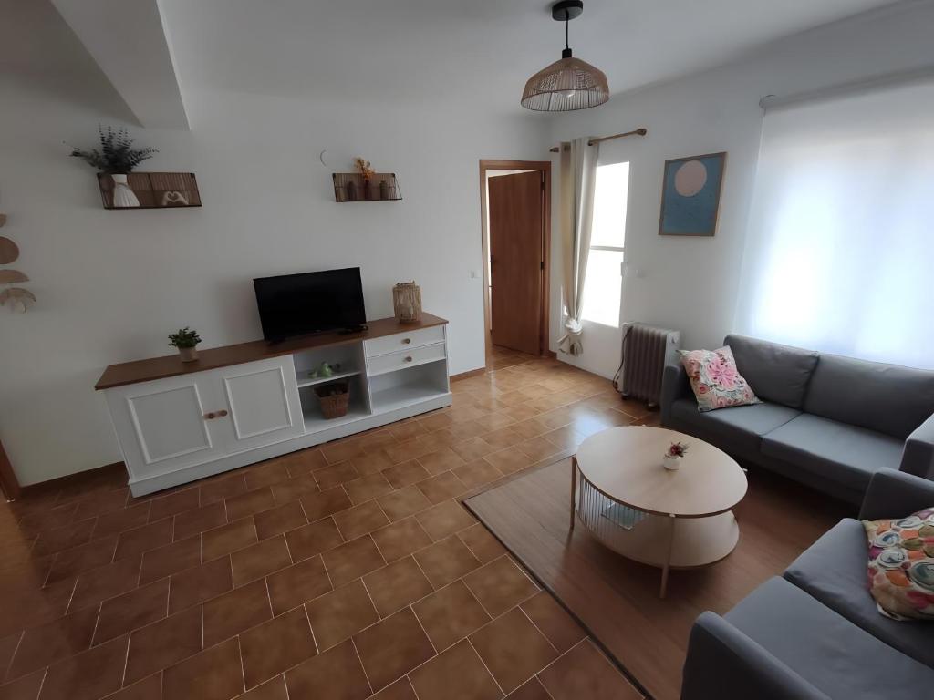 a living room with a couch and a tv at Casa Manito in El Barraco