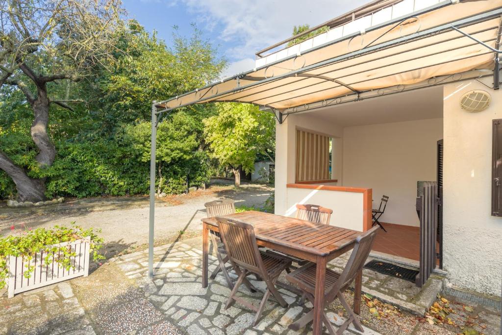 a patio with a wooden table and chairs at Monolocale casa Lucia in Campo nell'Elba