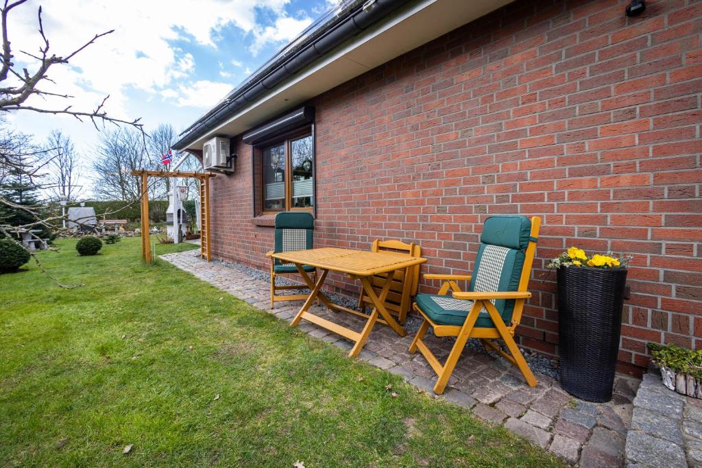 a table and chairs sitting next to a brick wall at Ferienwohnung Lemburg in Nindorf