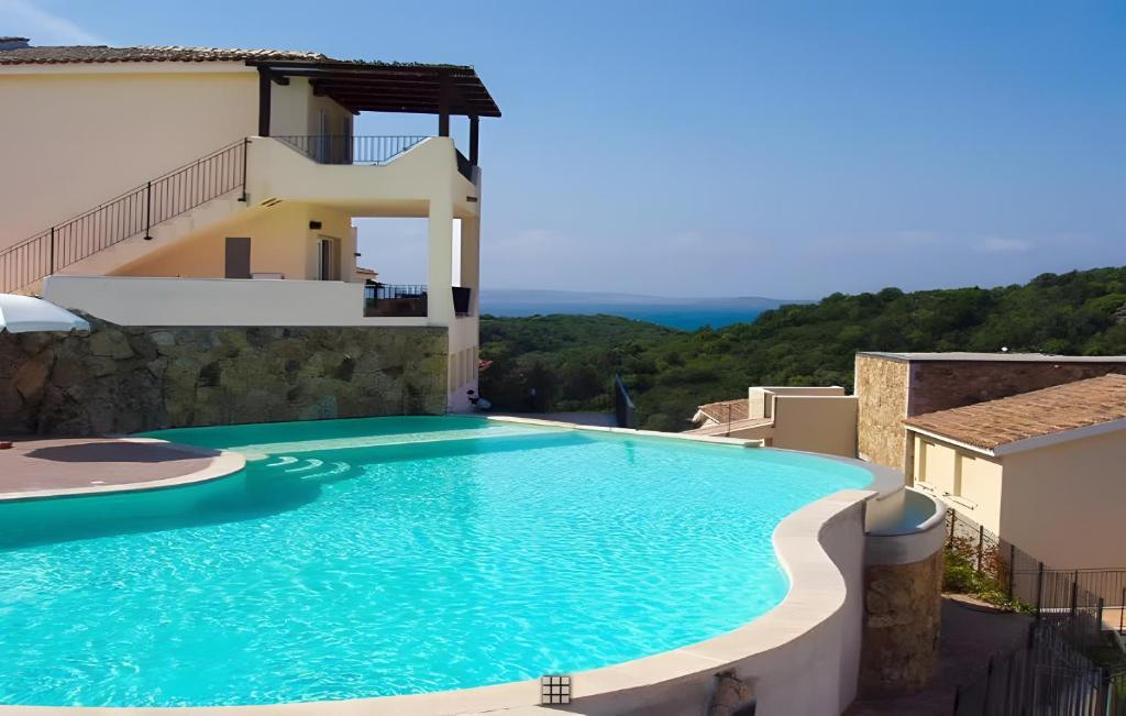 a swimming pool on the side of a villa at Apartment Simone in Baja Sardinia
