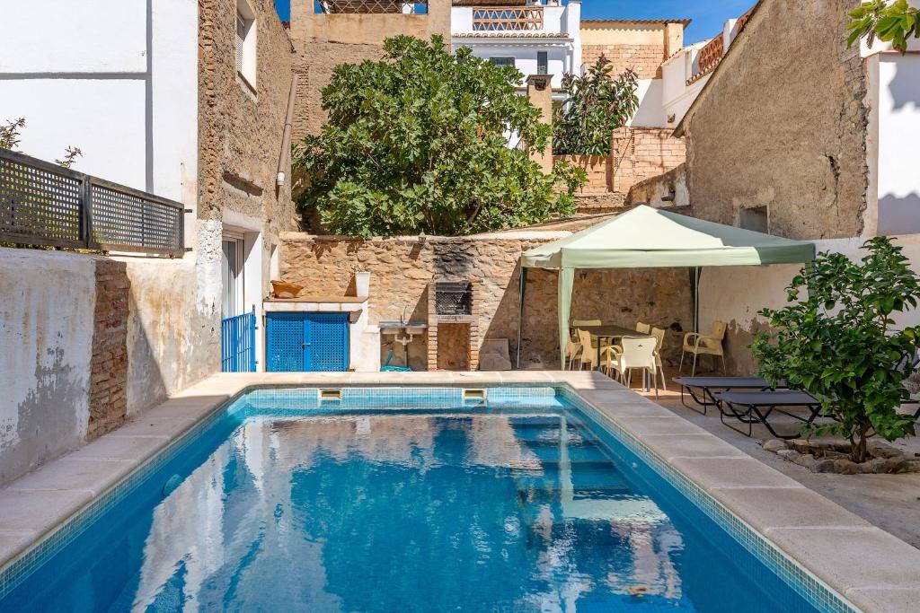 a swimming pool in the middle of a building at Casa Adriana con piscina in Murchas
