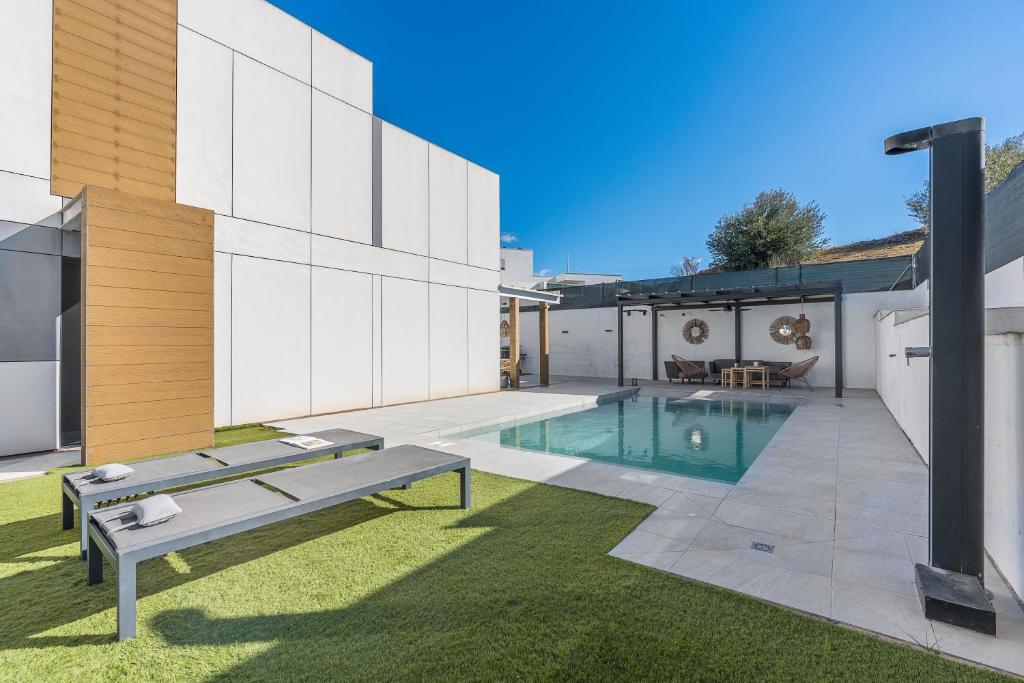 a backyard with a swimming pool and a house at Tu Paraíso Privado Con Piscina in Albolote