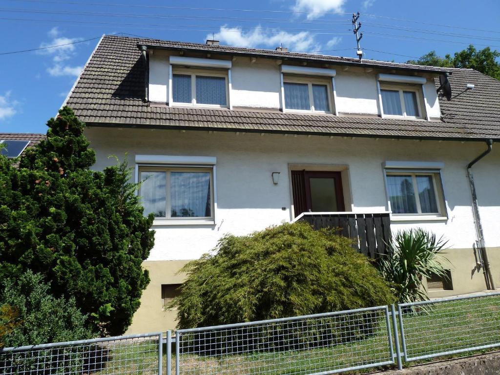 a white house with a fence in front of it at Ferienwohnung am Wald Schuttertal in Schuttertal