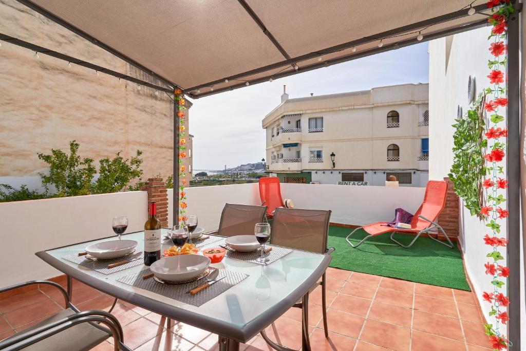 a table on a balcony with a view of a building at Estudio Quorum, centro de Nerja in Nerja