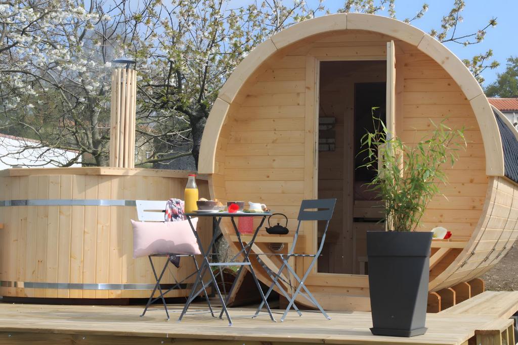 a small wooden sauna with a table in front of it at Barrel Papilles En Escapade in Sevremont
