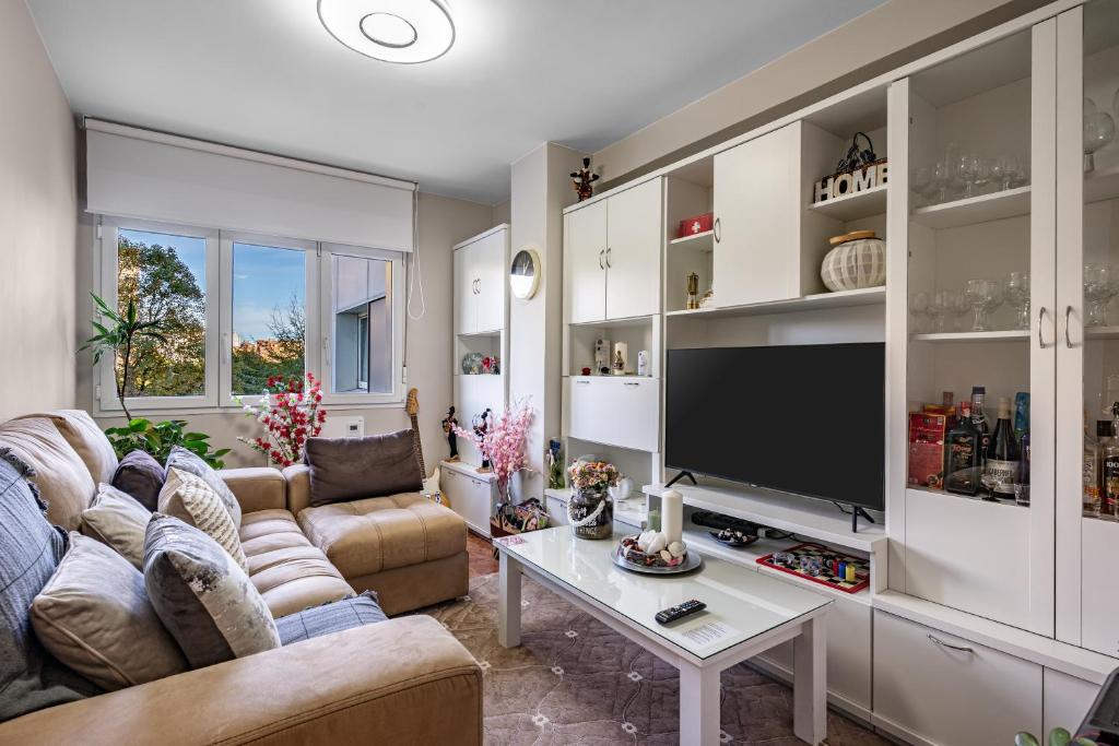 a living room with a couch and a tv at Rincón De Julia in Gijón