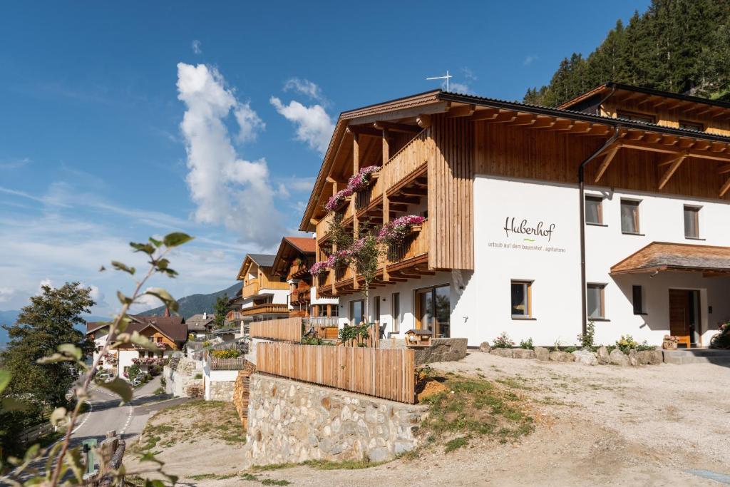 a building in the mountains with flowers on it at Huberhof Gais in Gais