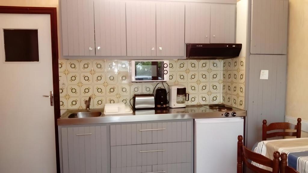a kitchen with a sink and a microwave at T2 Mimizan Plage in Mimizan-Plage