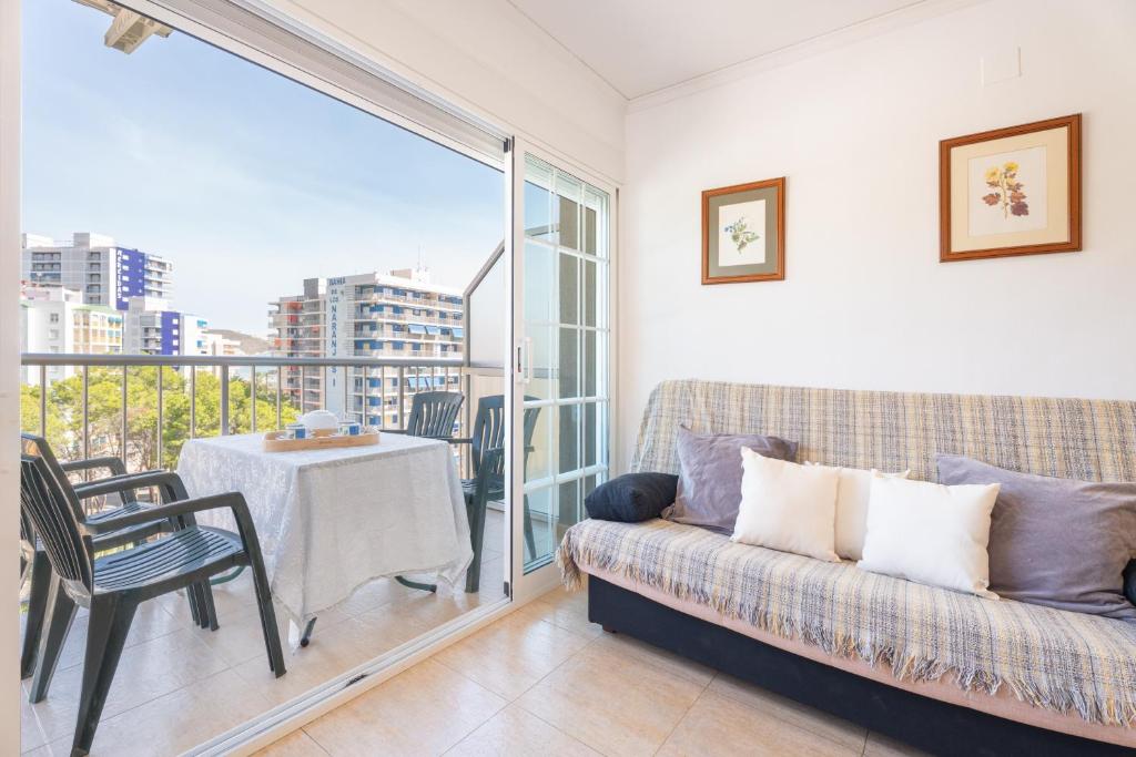 a living room with a couch and a balcony with a table at Mont Pele in Cullera