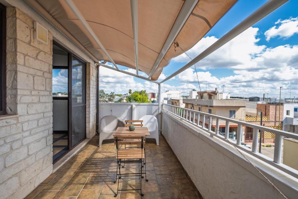 a balcony with a table and chairs on a building at Golden Bay Lux House in Torre Lapillo