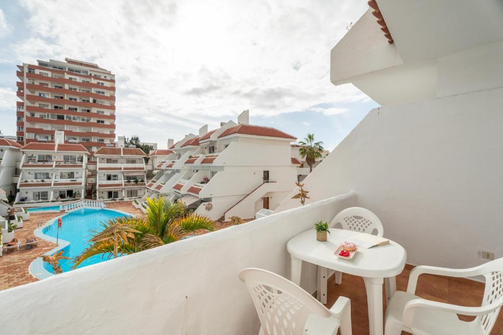 a balcony with a table and chairs and a pool at Infinity Pool Views 2 Las Floritas in Playa de las Americas