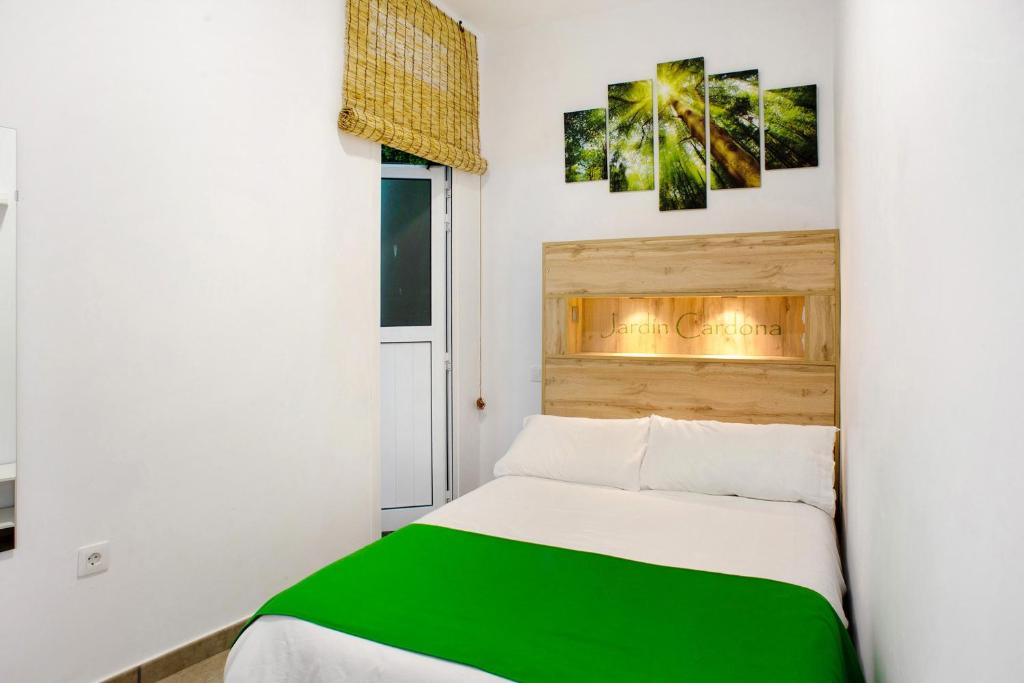 a small bedroom with a green and white bed at Jardin Cardona in Arucas