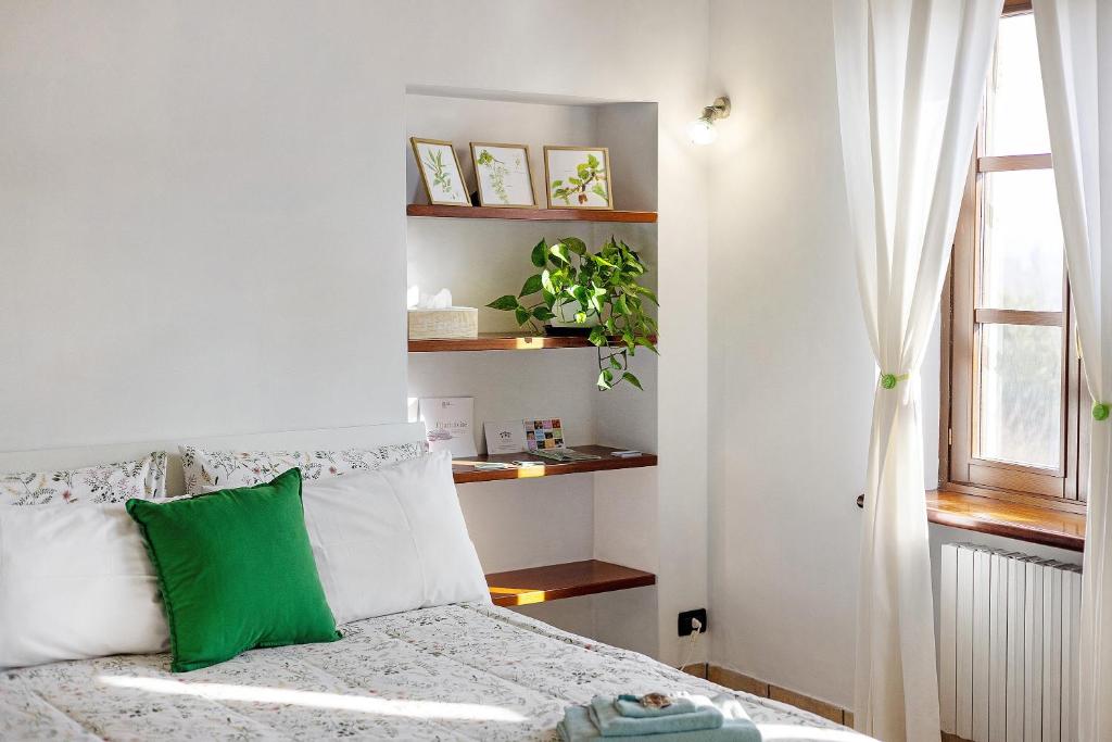 a bedroom with a bed with a green pillow at B_B La Rugiada in Tigliole