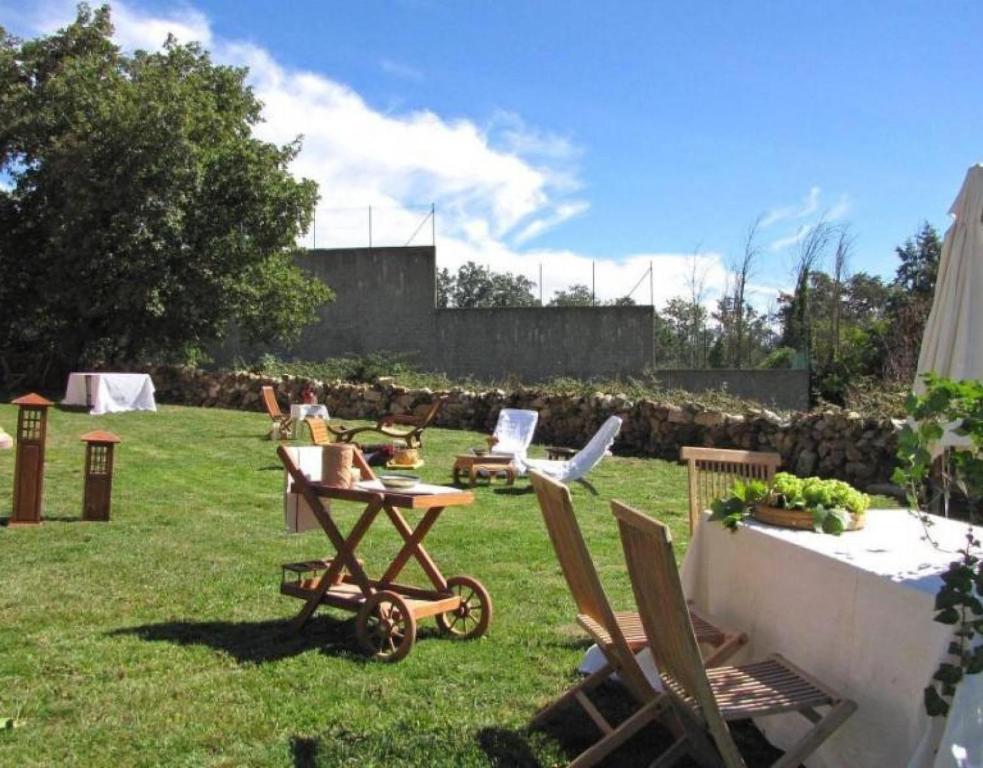 a yard with chairs and a table in the grass at Vivir en el Campo in Cidones