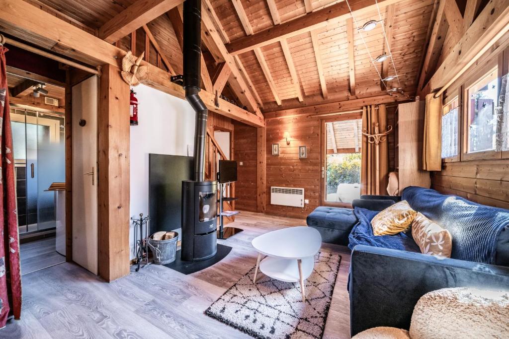 a living room with a blue couch and a tv at Chalet 6p Classique - Les Gentianes in Verchaix