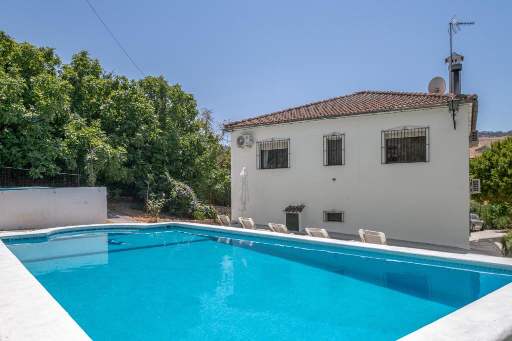 a swimming pool in front of a house at Casa El Molino in Montecorto