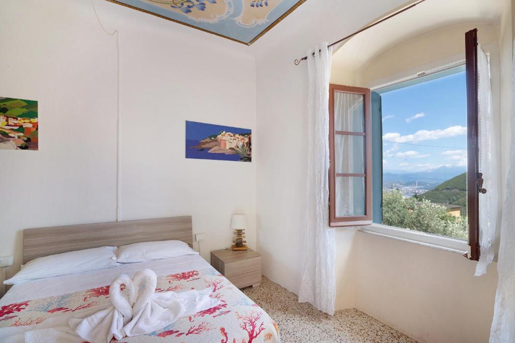 ein Schlafzimmer mit einem Bett und einem großen Fenster in der Unterkunft Acciuga House in Biassa