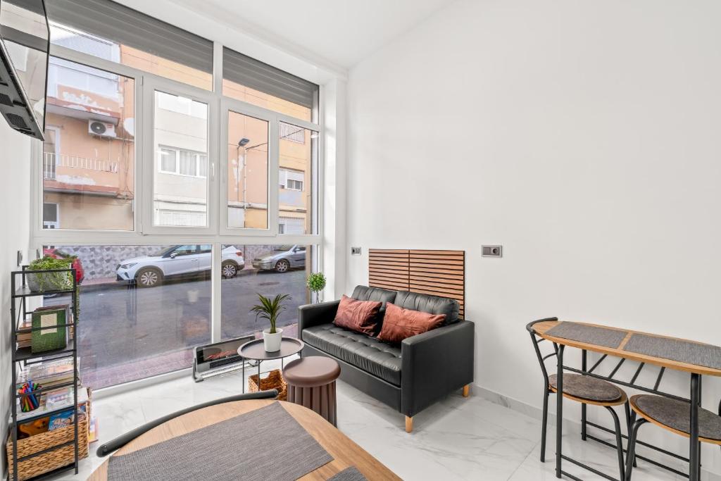 a living room with a couch and a large window at Vima Lofts in Torrevieja