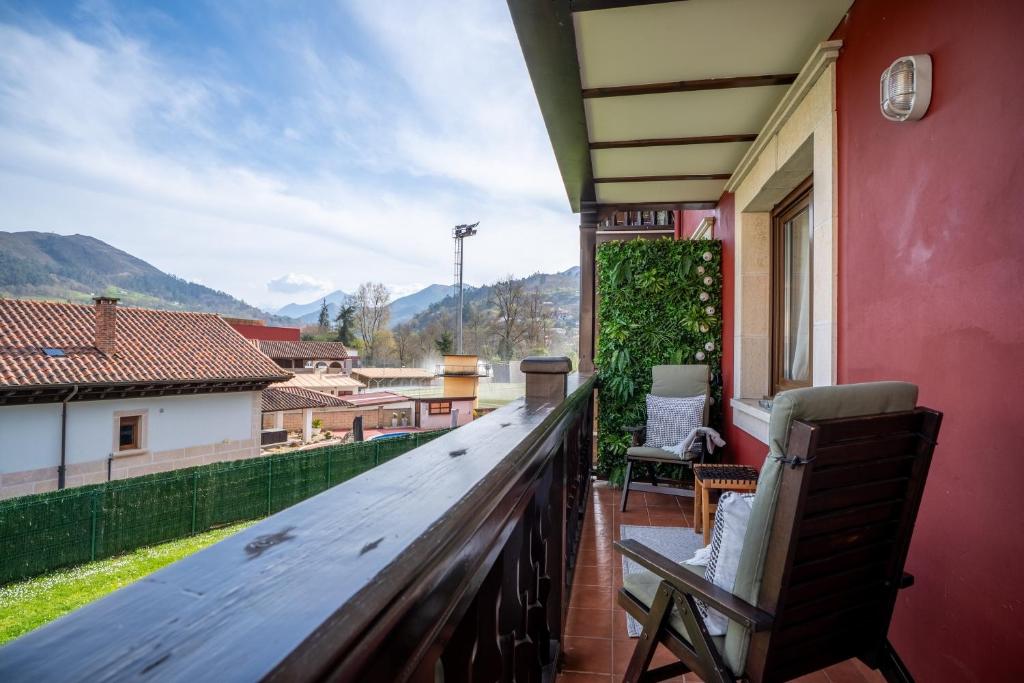 a balcony with a wooden table and chairs on a house at 'Salmosalar' Cangas de Onís in Cangas de Onís