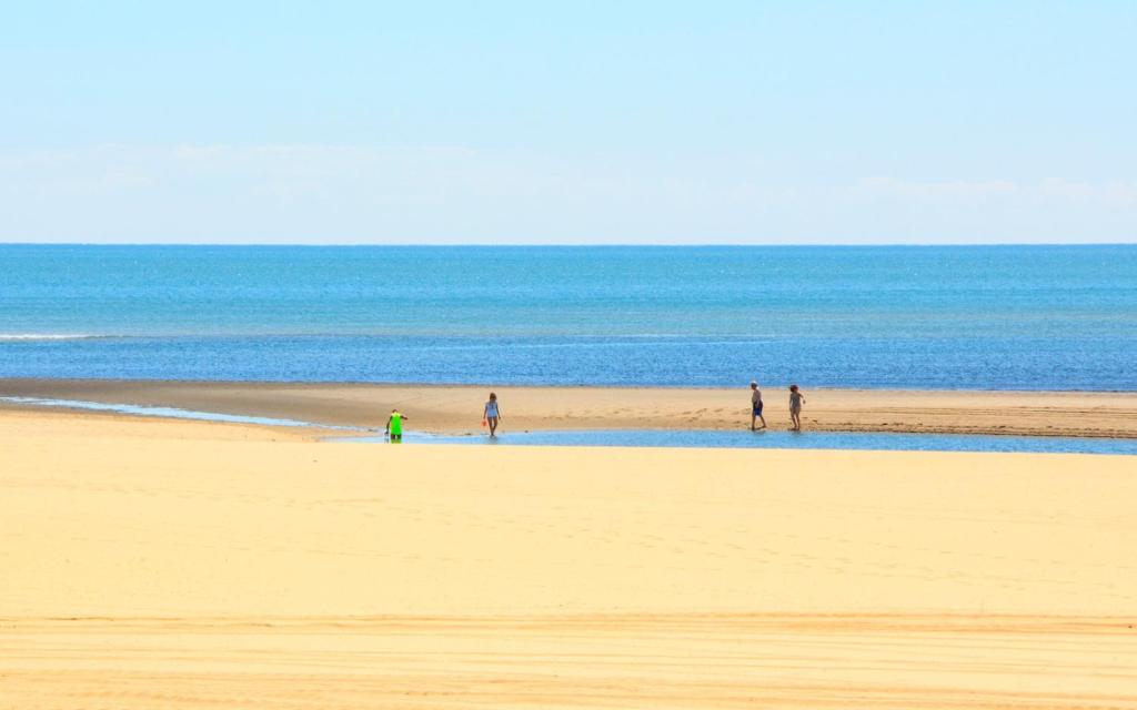 a group of people standing on a beach at Coral Bungalow in Ayamonte